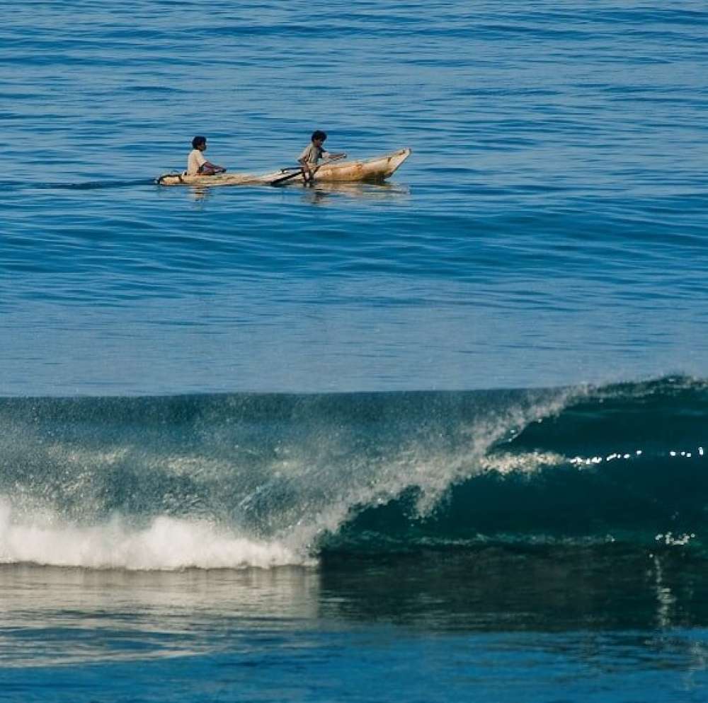 Local fishermen canoeing off of Nihiwatu Beach